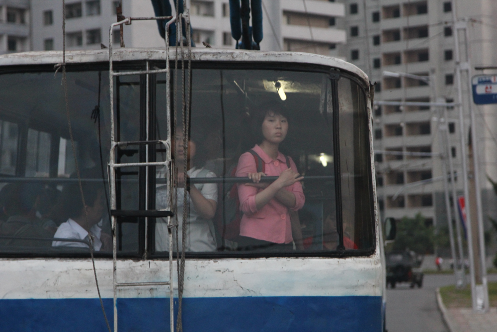 Eine Frau schaut hinten aus dem Bus