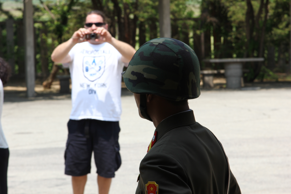 Ein Soldat wird von einem Touristen fotografiert