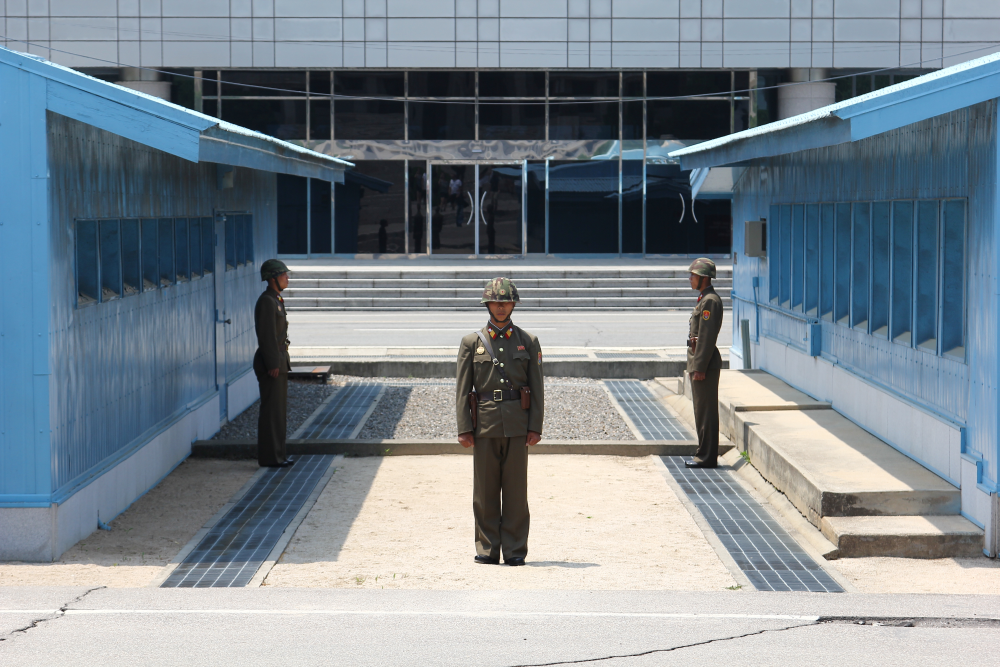 Drei nordkoreanische Soldaten vor der nord-südkoreanischen Grenze