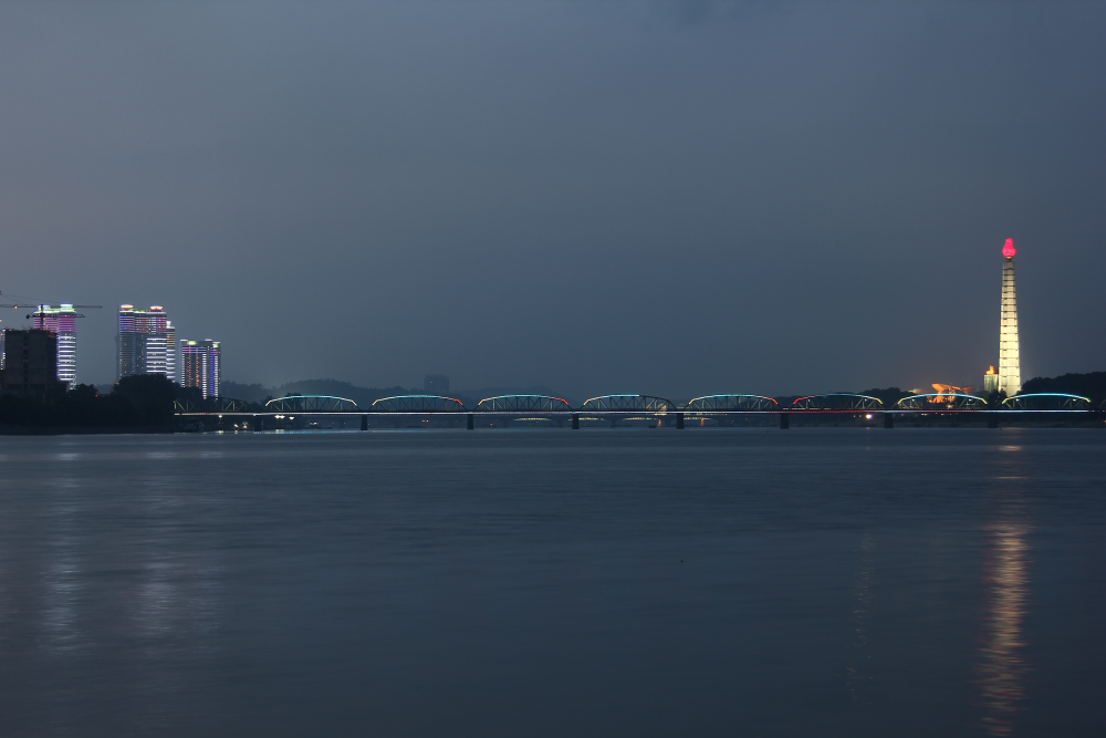 Fluss und der Turm der Juche-Idee bei Nacht